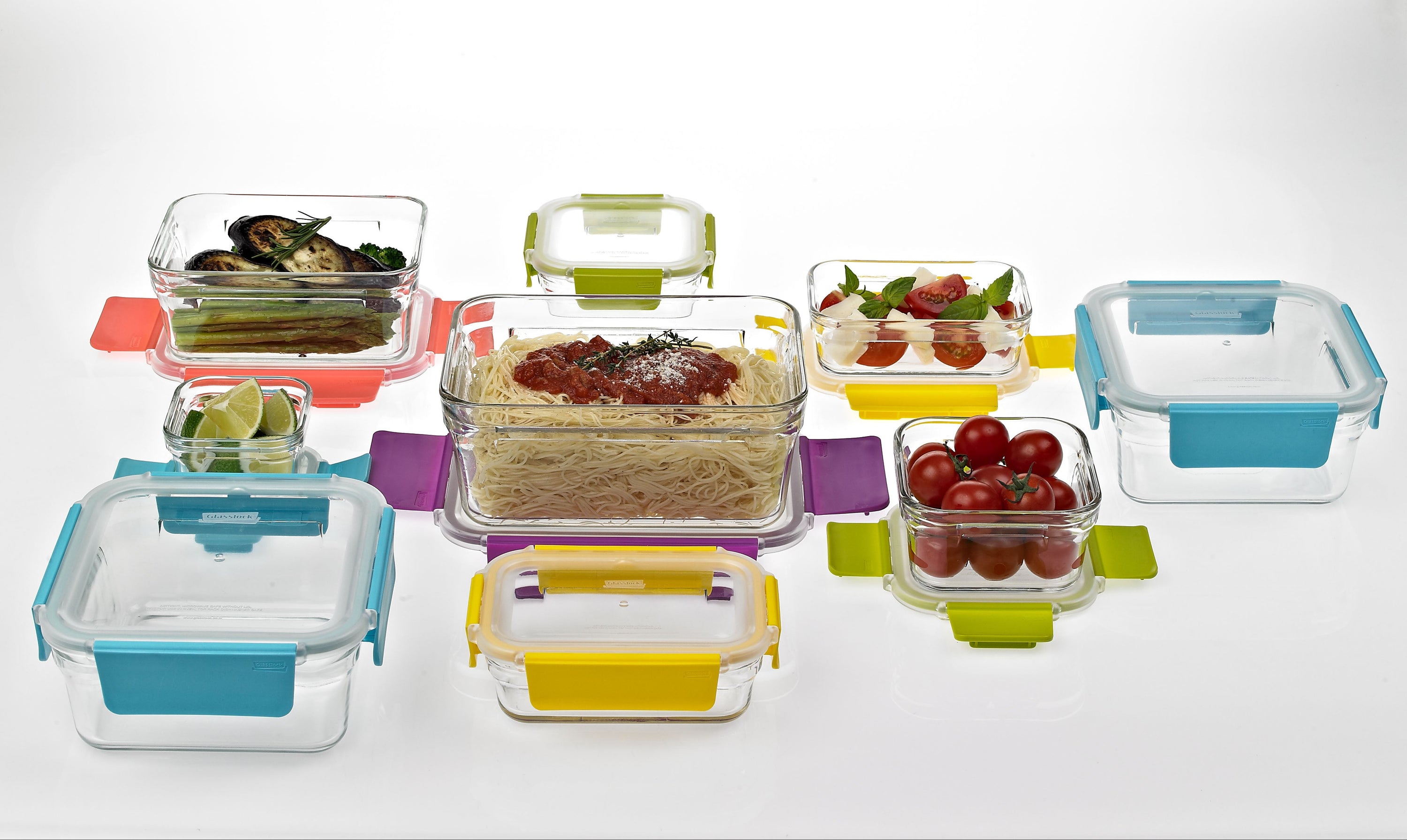 Set of glass food containers with colorful lids on a white background