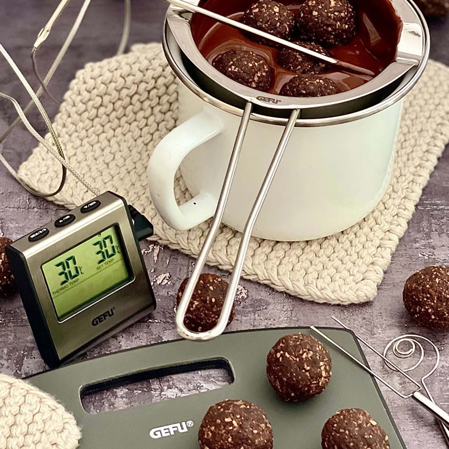 Digital roast thermometer with timer, probe and display near roast meat in pan