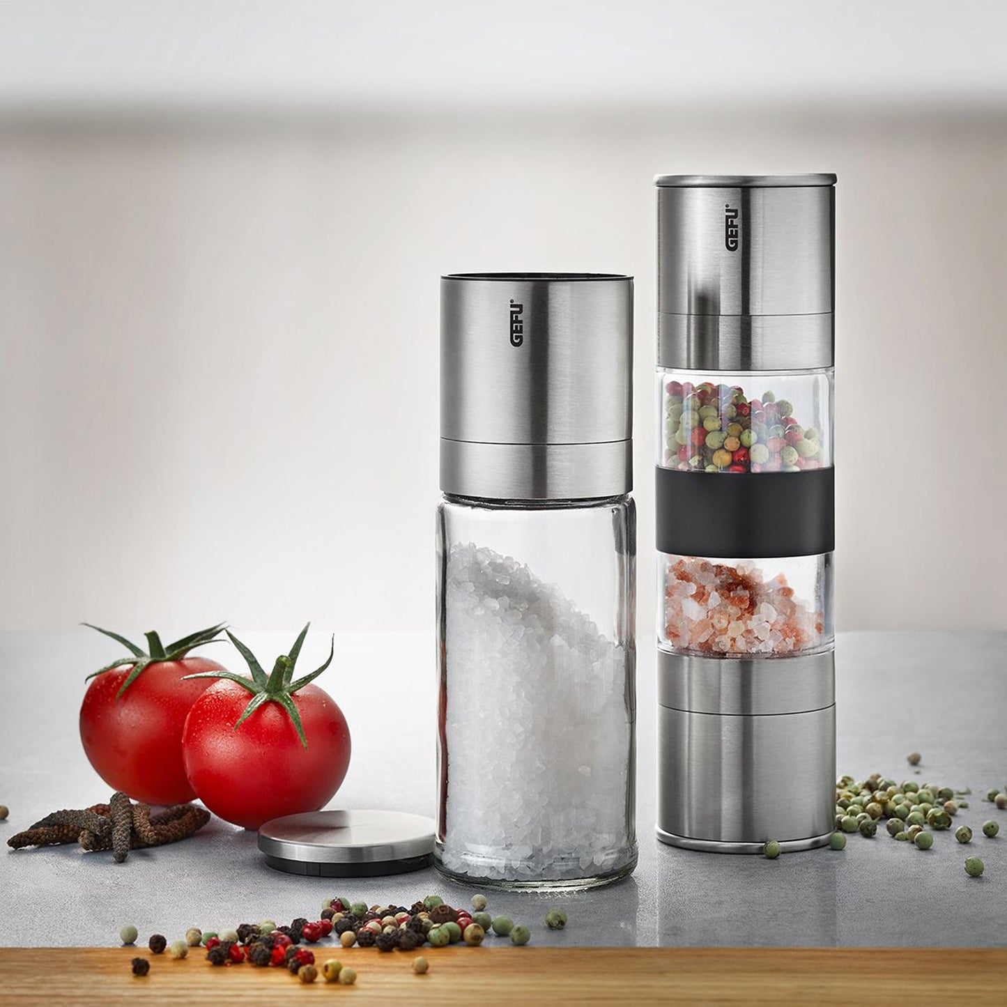 Two stainless steel salt and pepper mills with transparent spice chambers