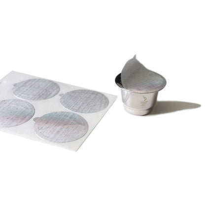 Stick-on aroma seal sheet with gray circles and one loose seal in small cup
