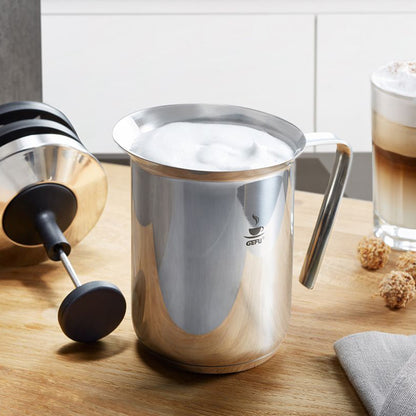 Stainless steel milk frother pitcher with black frothing whisk disc, handle, GEfU logo