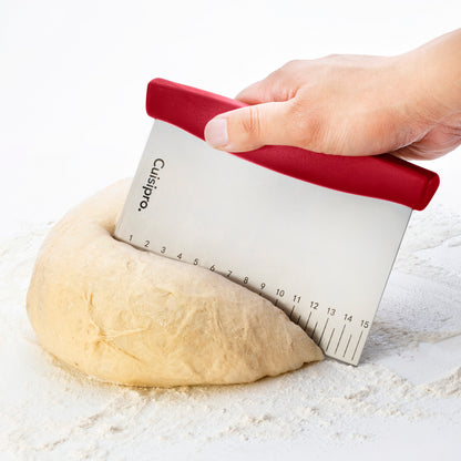 Dough cutter with red handle pressing dough against a numbered measuring scale