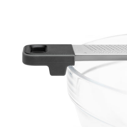 Kitchen grater close-up with black end cap and ridged stainless grating