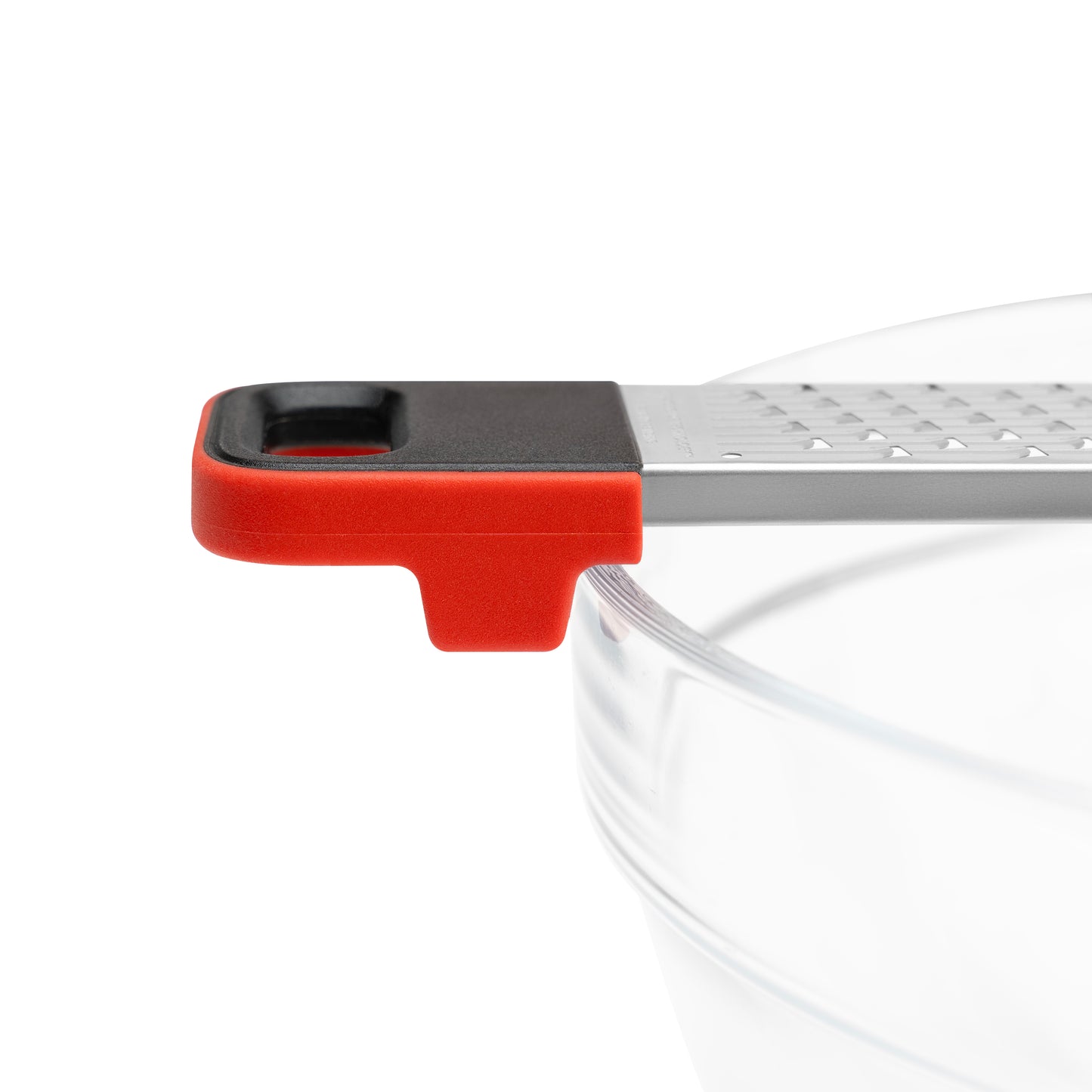 Kitchen grater with red base section and stainless grating over a bowl rim