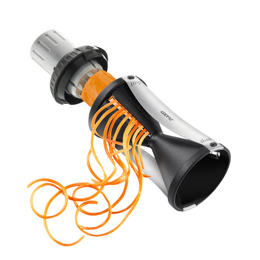 Spiral slicer with silver body and black cone, cutting orange vegetable spirals