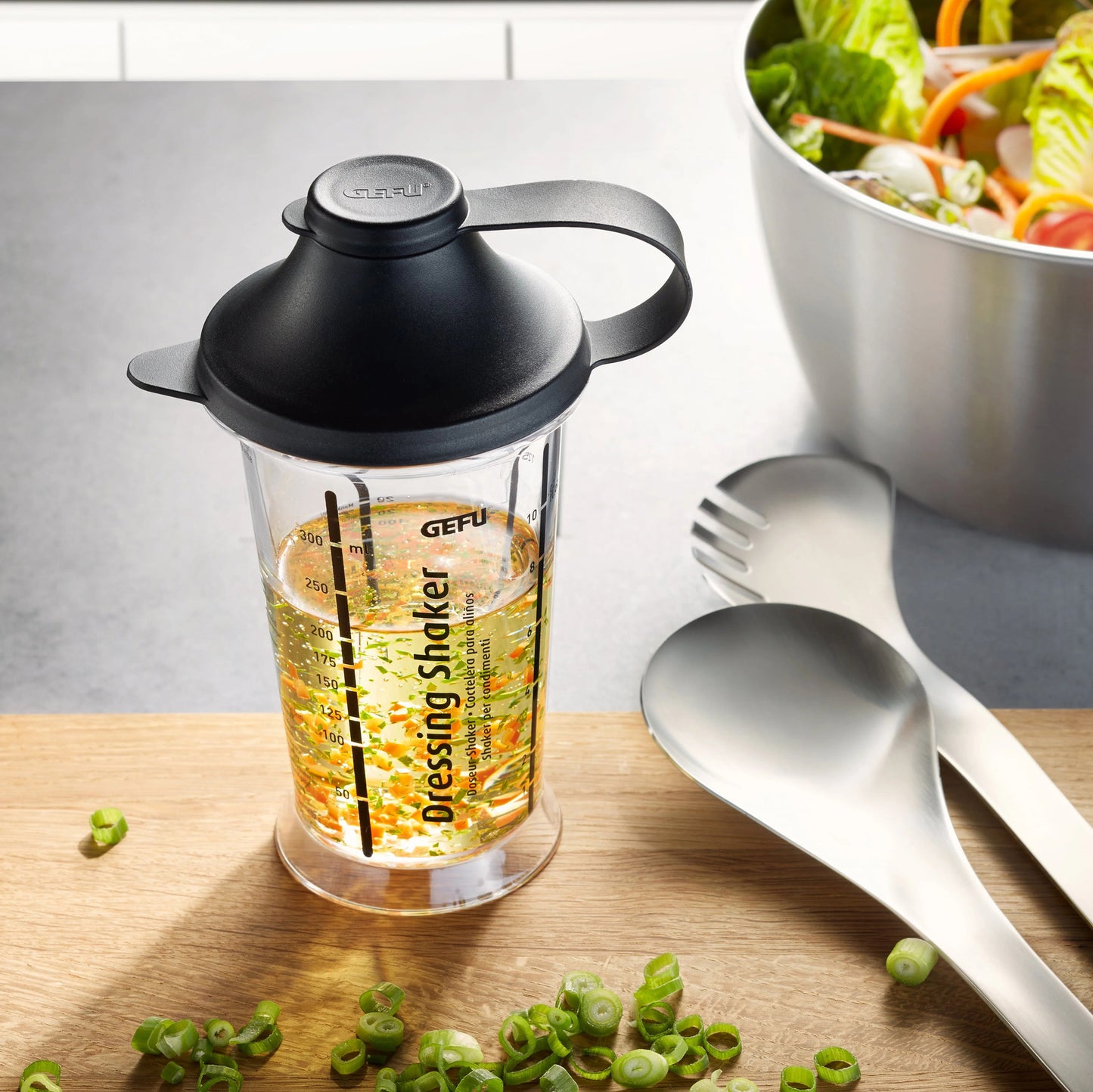 Dressing shaker with black lid and handle, clear cup with printed measurement scale