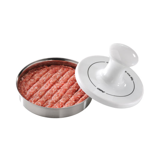 Hamburger burger press with white lever over metal tray of ground meat patties