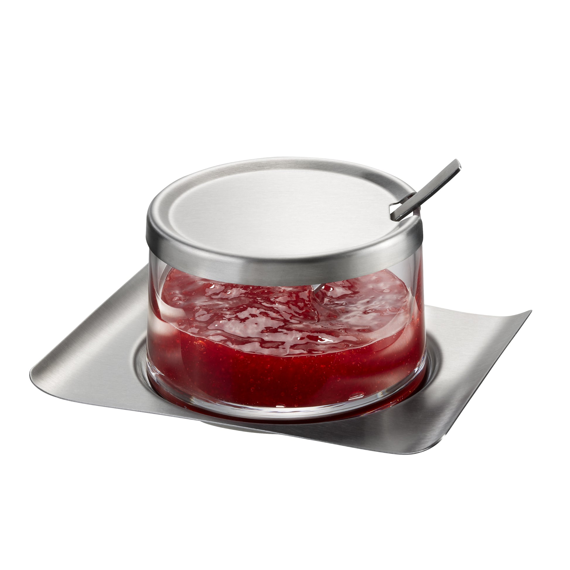 Glass jam jar with metal lid and spoon, filled with red jam on tray