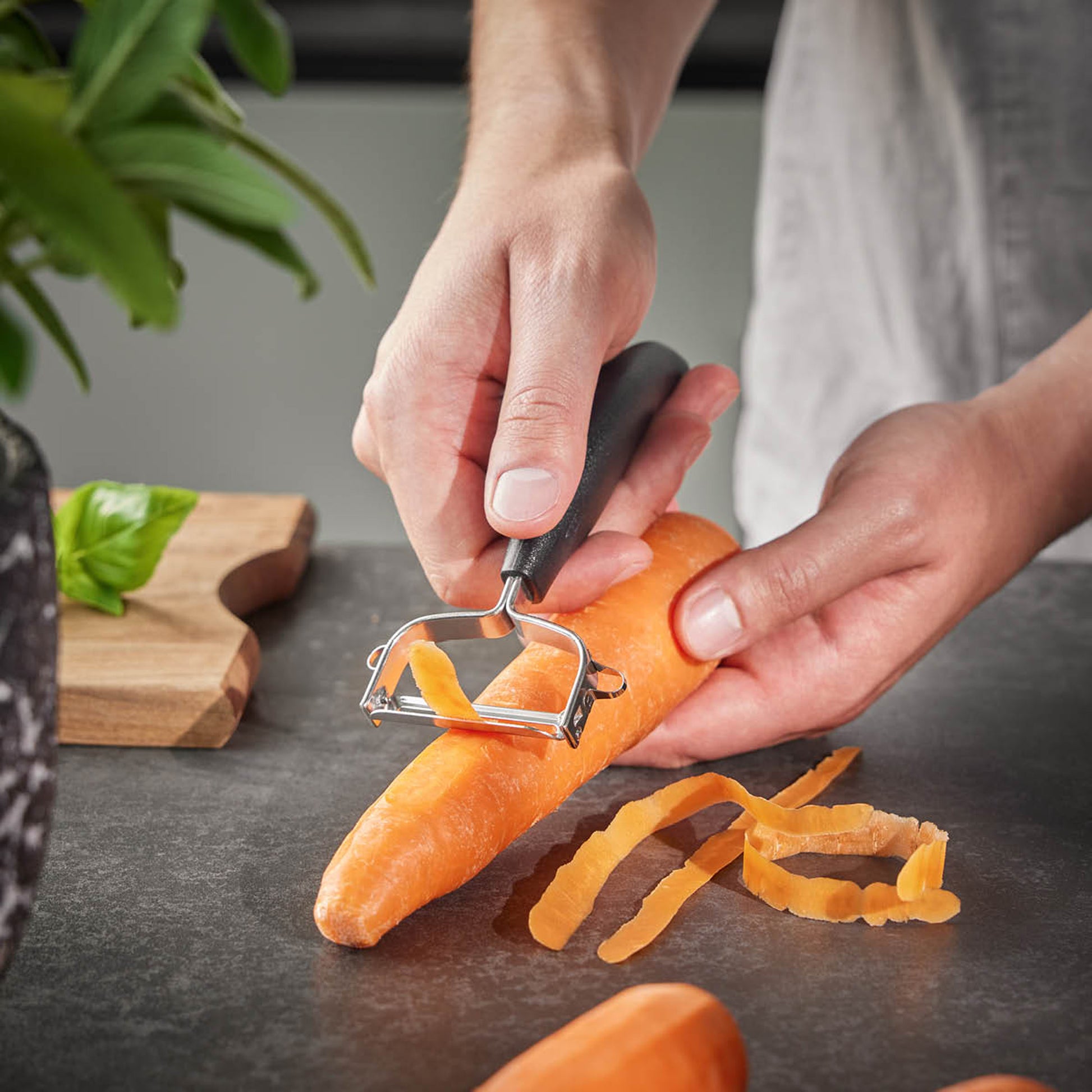 UNIVERSALE universal peeler in use on an orange carrot