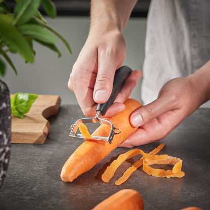 UNIVERSALE universal peeler in use on an orange carrot