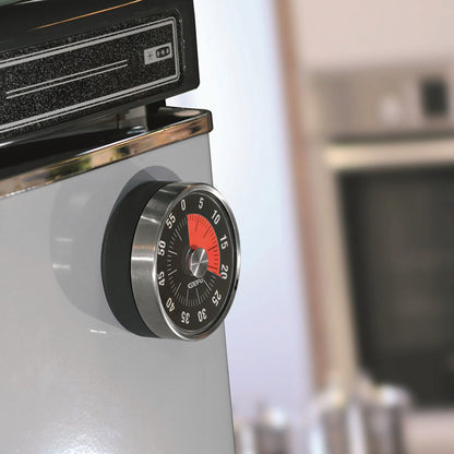 Countertop timer dial mounted on appliance, red scale on dark face