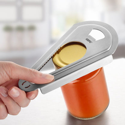 Handheld silver 4-in-1 opener pulling a bottle cap; finger grip and serrated edge