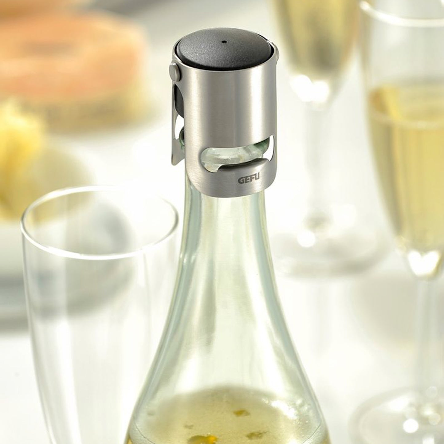 Sparkling wine stopper on bottle neck with black top and metal collar