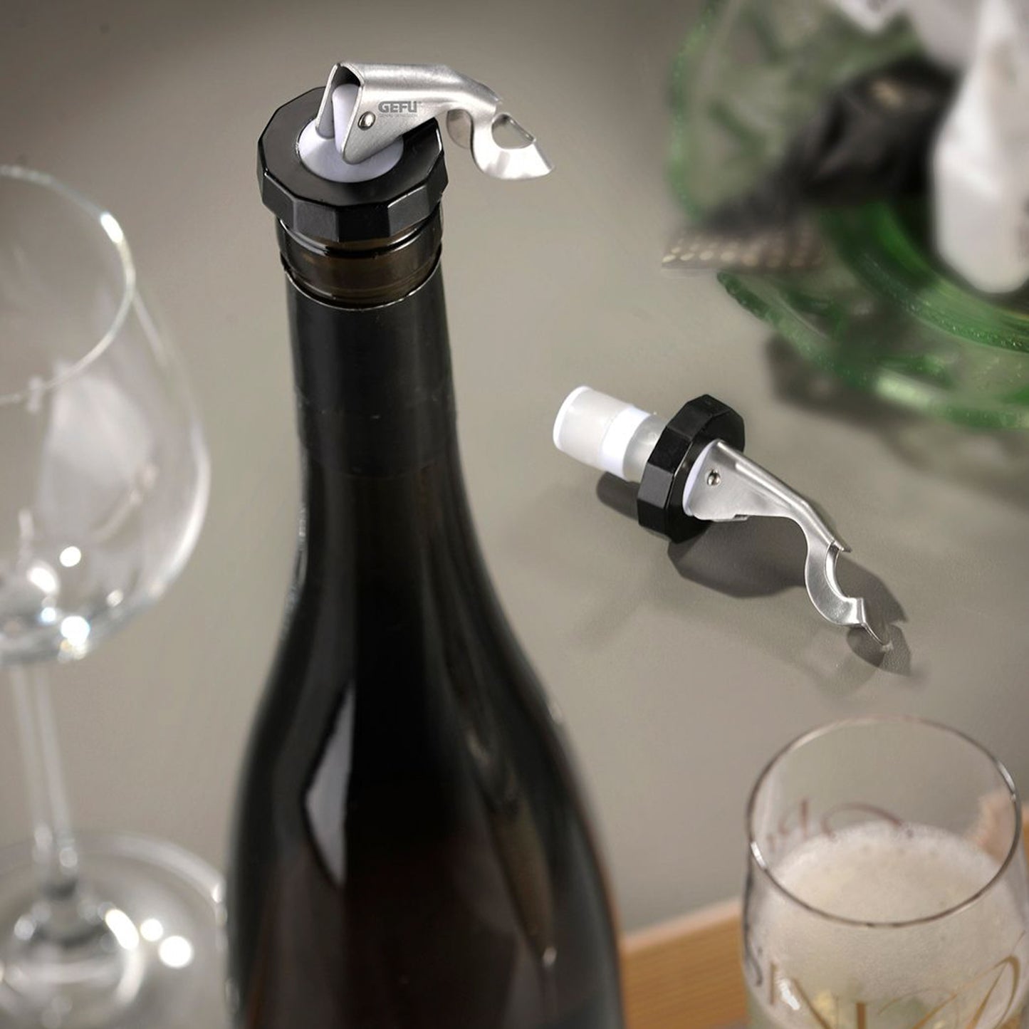 Bottle stopper with black cap and chrome lever on dark glass bottle