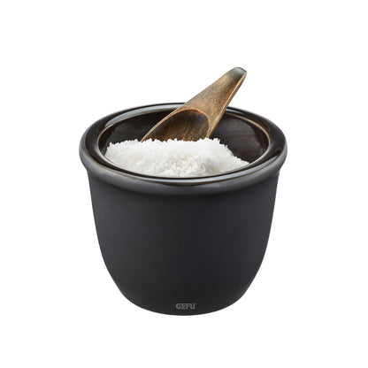 Black ceramic salt and spice pot with wooden spoon, open top filled with white salt