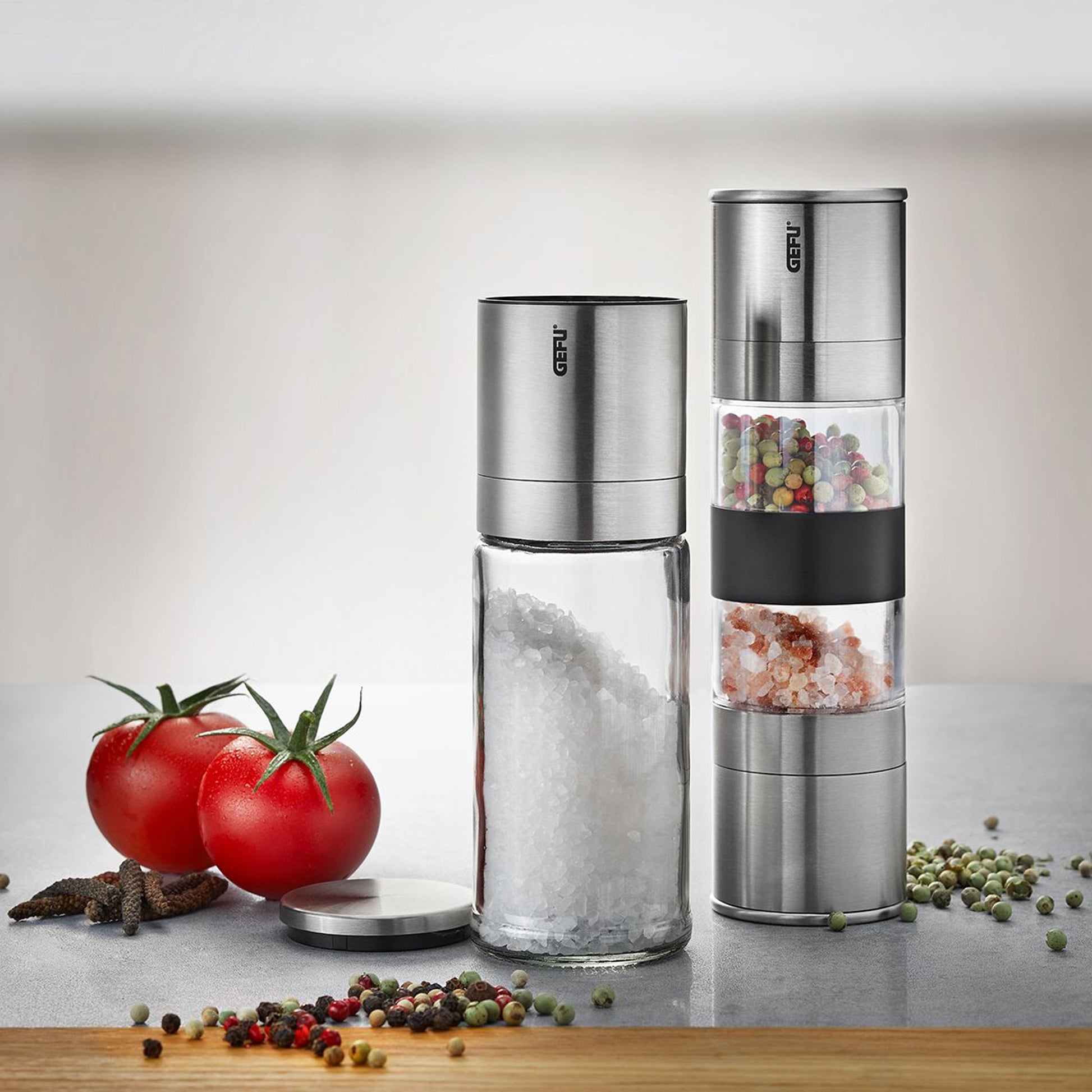 Two stainless steel salt and pepper mills with transparent spice chambers