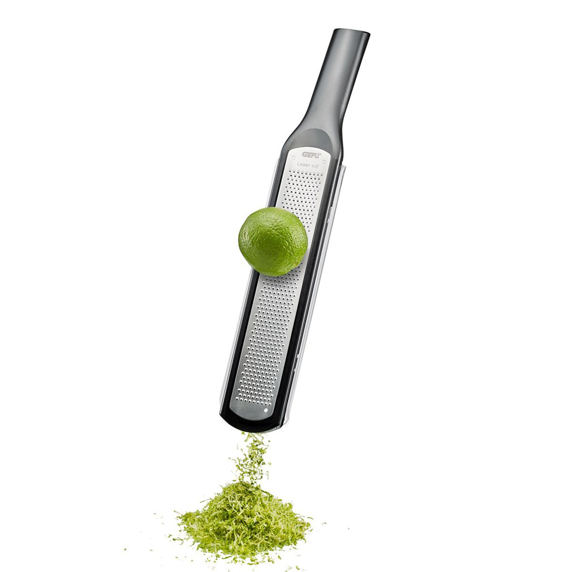 Handheld fine grater grating a green lime, producing fine shreds