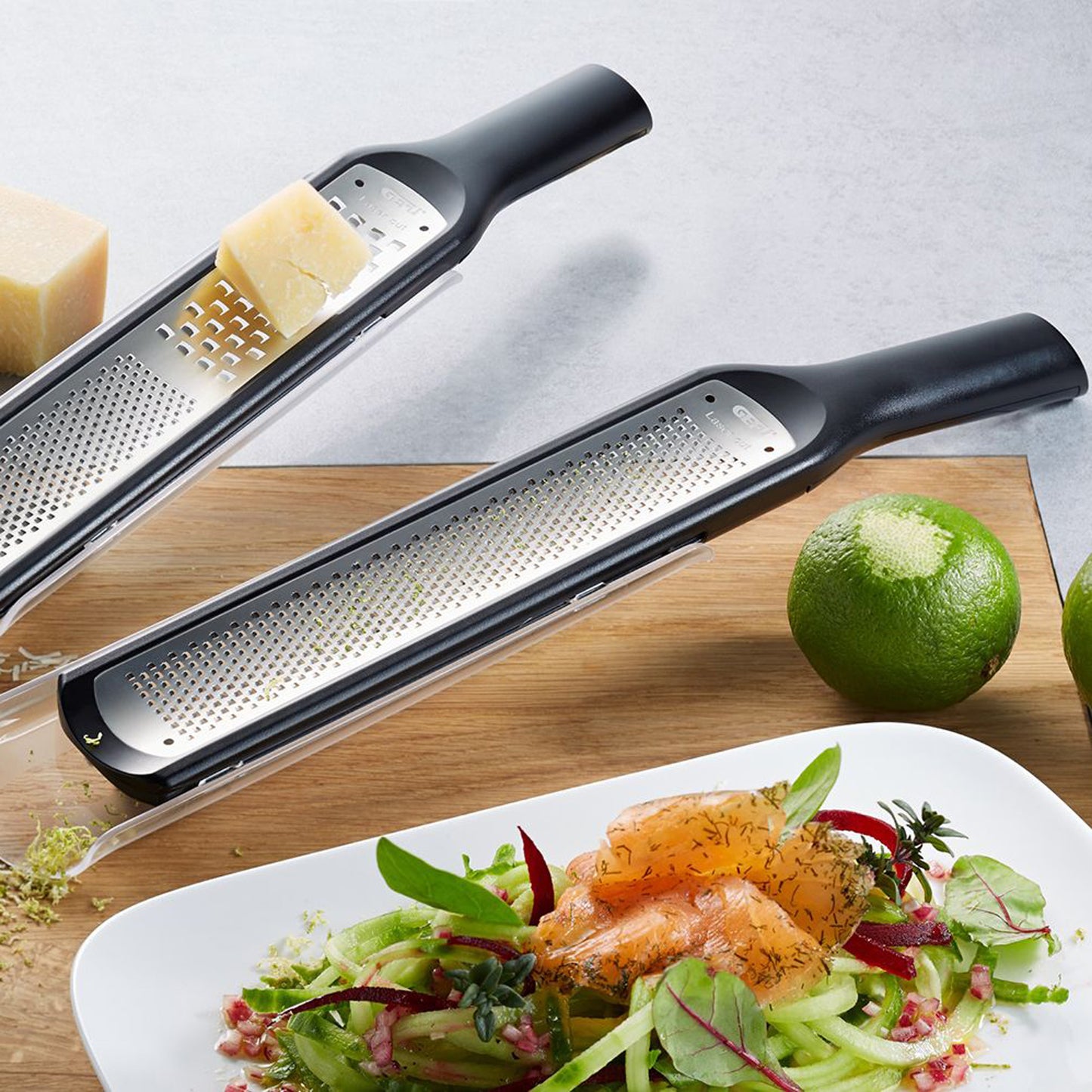 Two fine graters with black handles and perforated grating surfaces