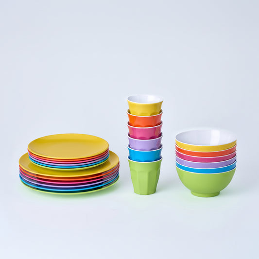 Set of colorful ceramic plates and bowls on a white background