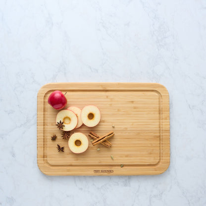 Bamboo chopping board with shallow rim groove, topped with sliced onions and spices