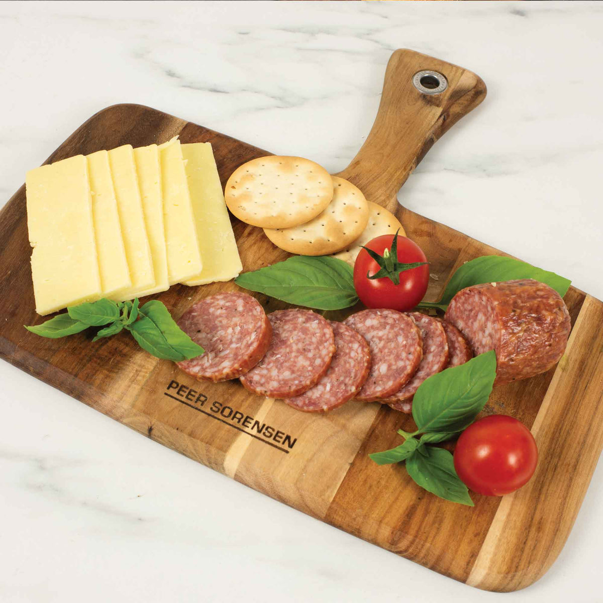 Rectangular wooden serving board with thumb-hole handle, marked Peer Sorensen.