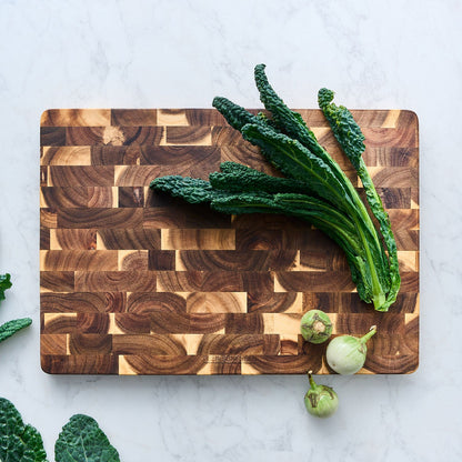 End grain cutting board with kale and onions on top, end-grain wood pattern
