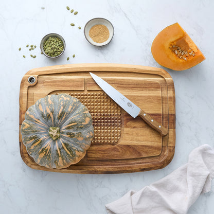 Wood reversible carving board with textured insert and carving knife on surface