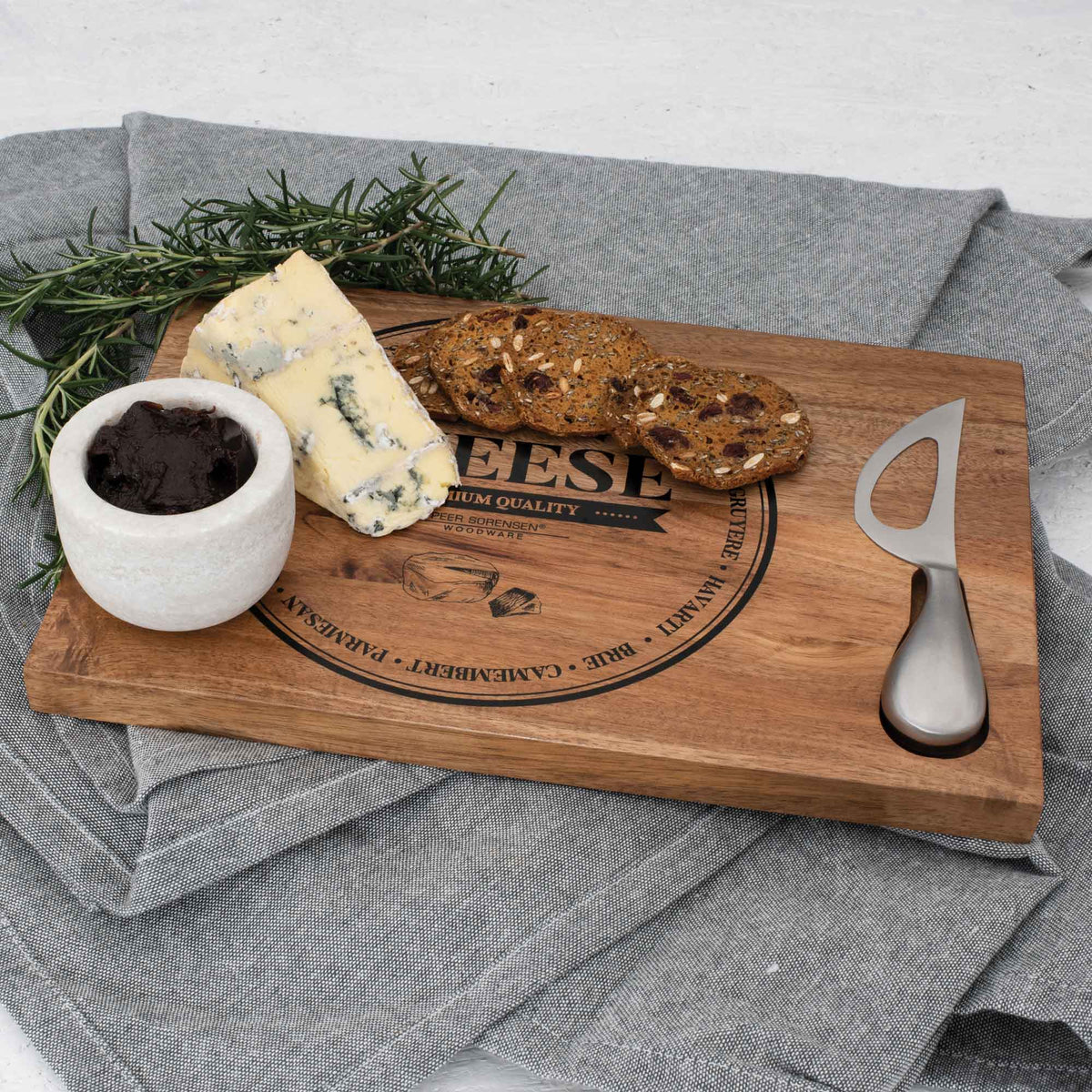 Rectangular wooden cheese board with handle cutout, cheese knife, crackers and cheese wedge