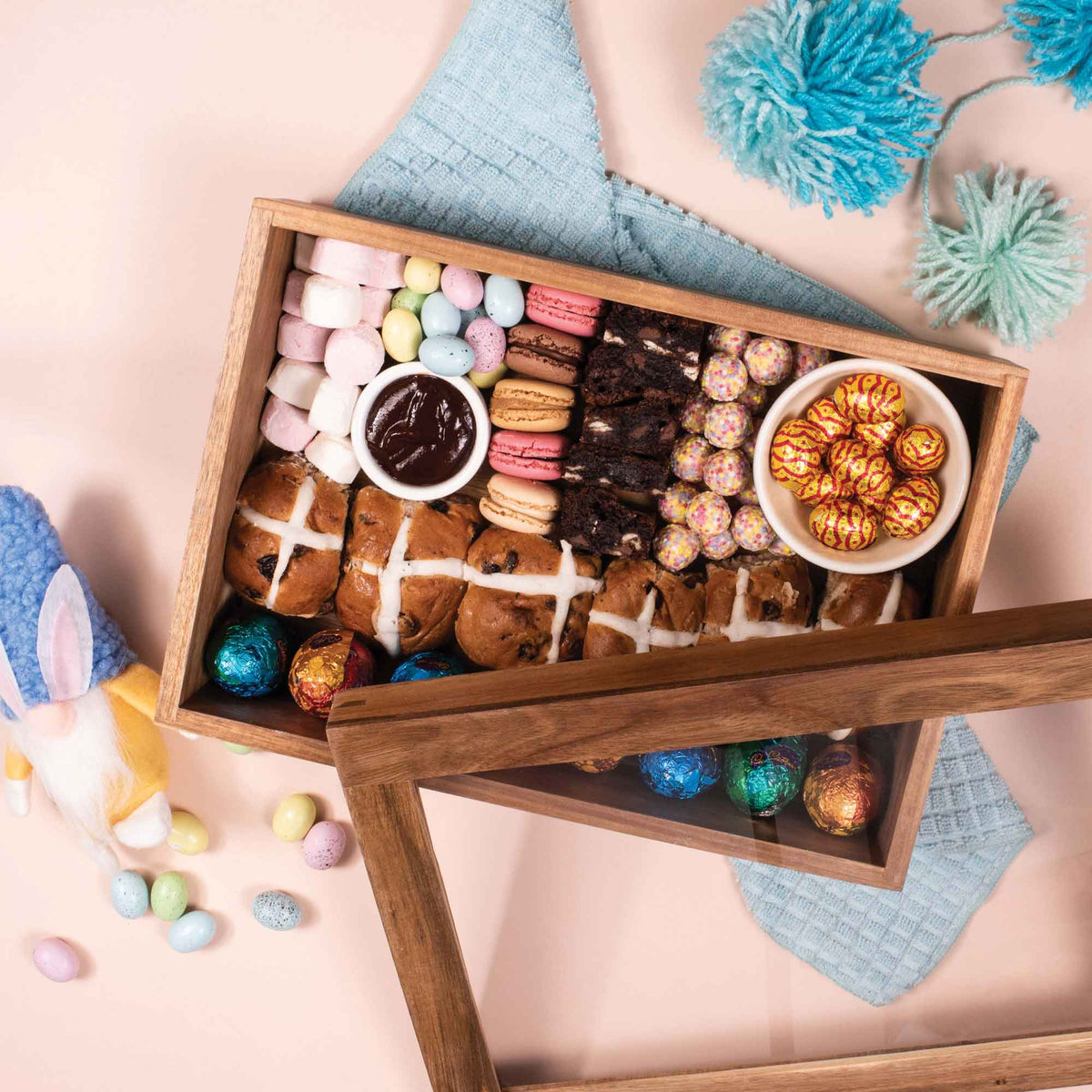 Wooden grazing box filled with colorful treats and snack bowls