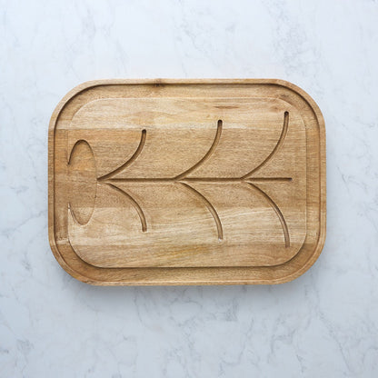 Mangowood cutting and serving board with carved curved pattern and recessed edges