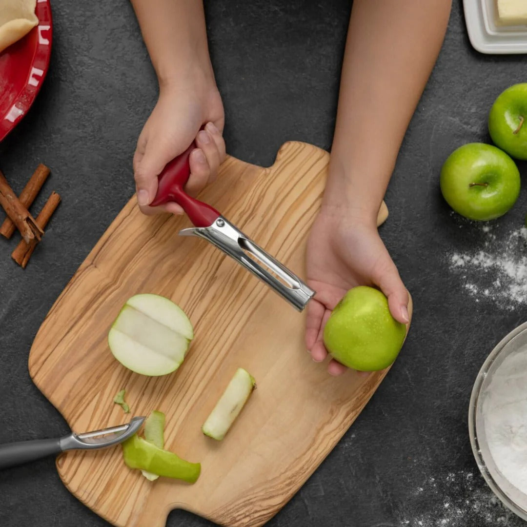 Apple corer in use with red handle, coring an apple on a cutting board