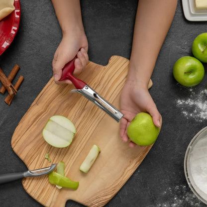 Apple corer in use with red handle, coring an apple on a cutting board