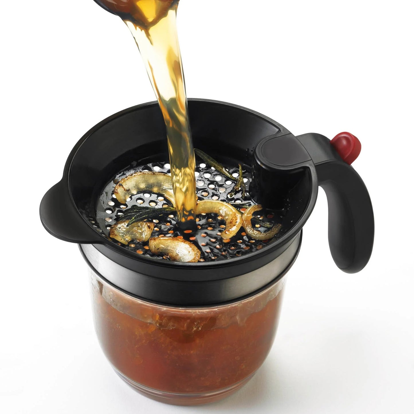Fat separator with black strainer as hot liquid pours in, separating food residue