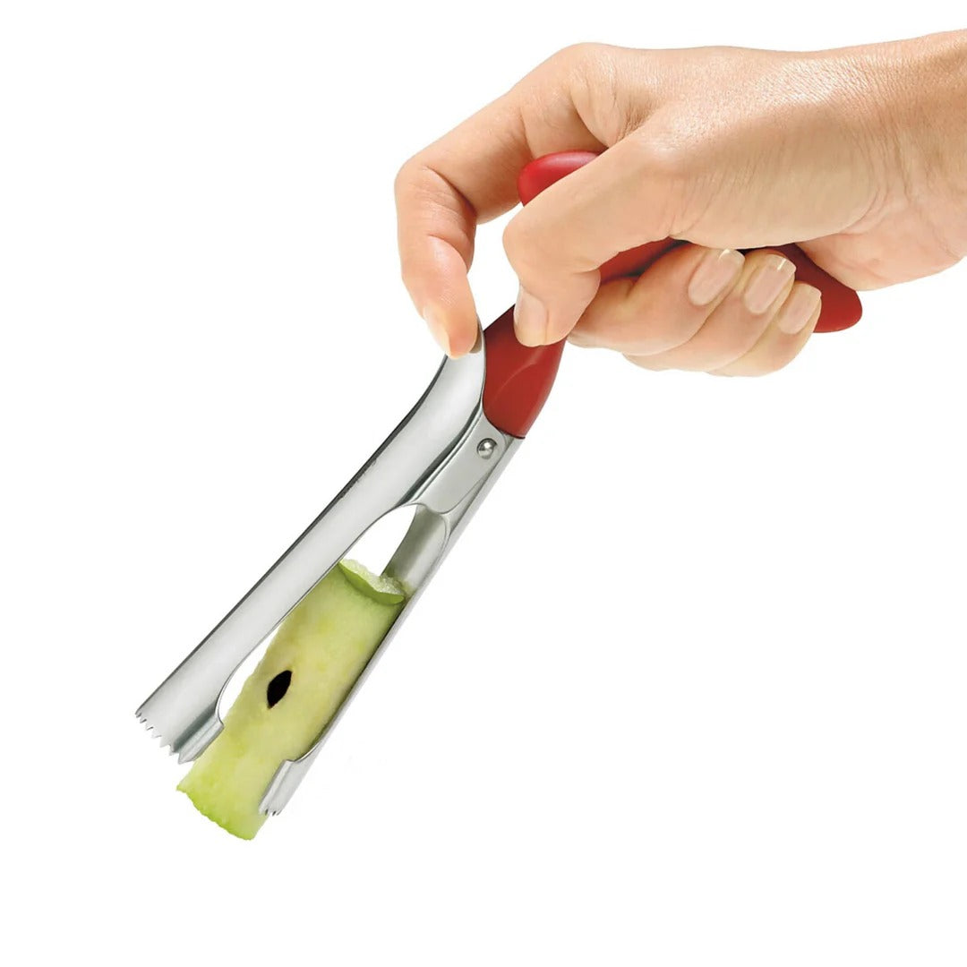Close-up: red-handled stainless apple corer with toothed tip and metal shaft