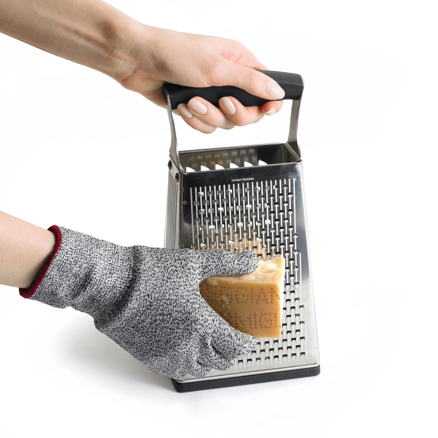 Grey cut-resistant glove with red cuff, hand holding a box grater