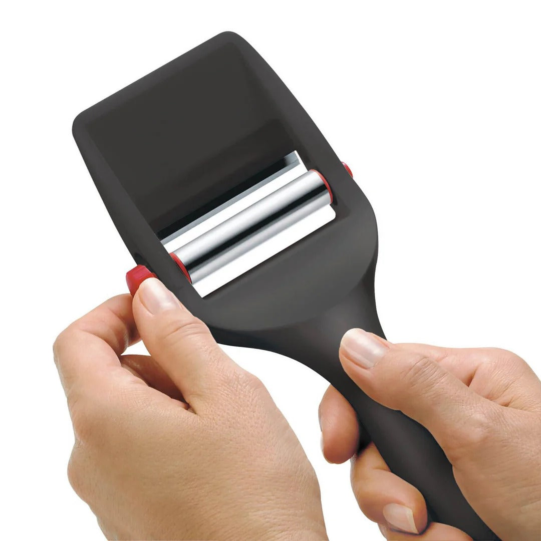 Black cheese slicer with exposed roller bar and red adjustment knob