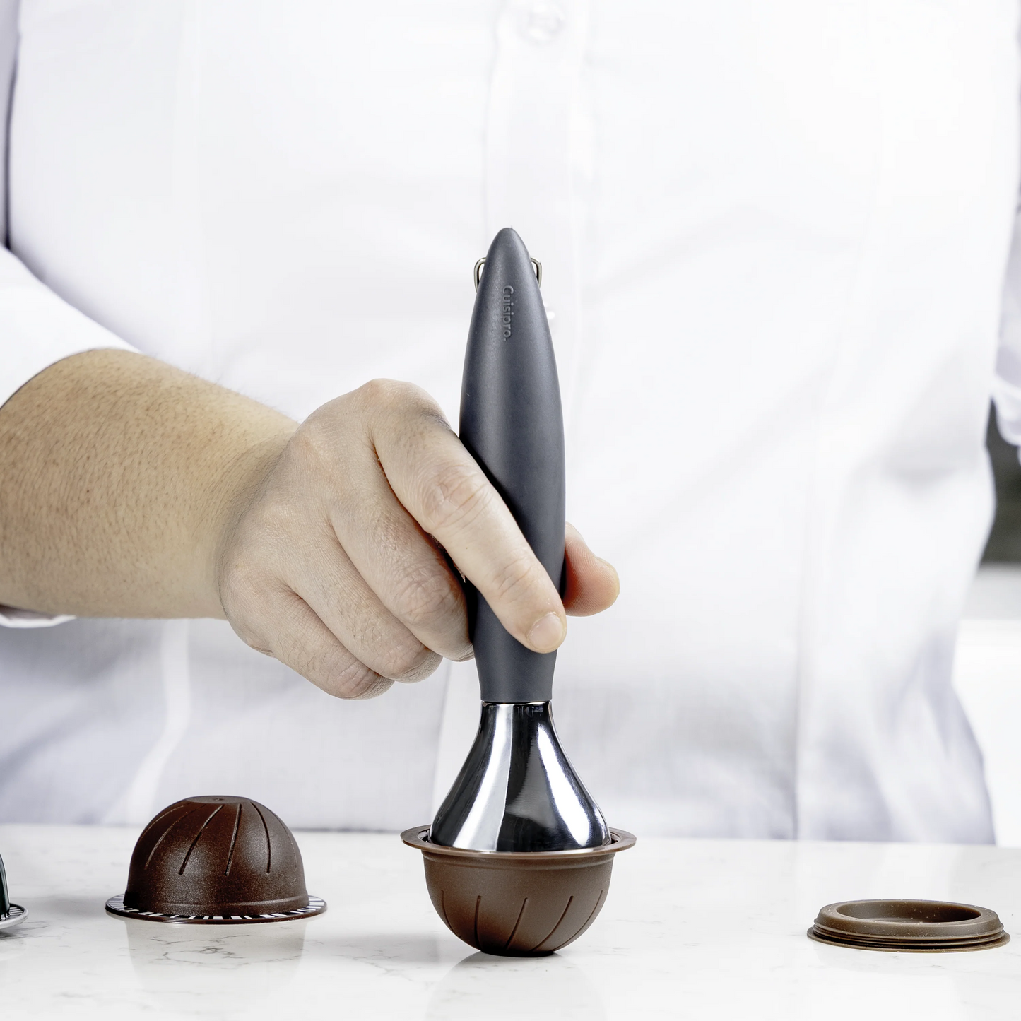 Coffee tamper with dark handle and chrome base, set on a portafilter