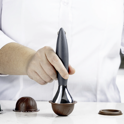 Coffee tamper with dark handle and chrome base, set on a portafilter