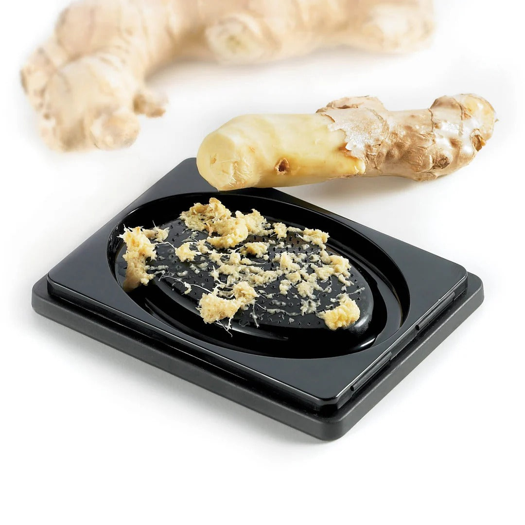 Black and gray 4-sided box grater with grated food on a square tray