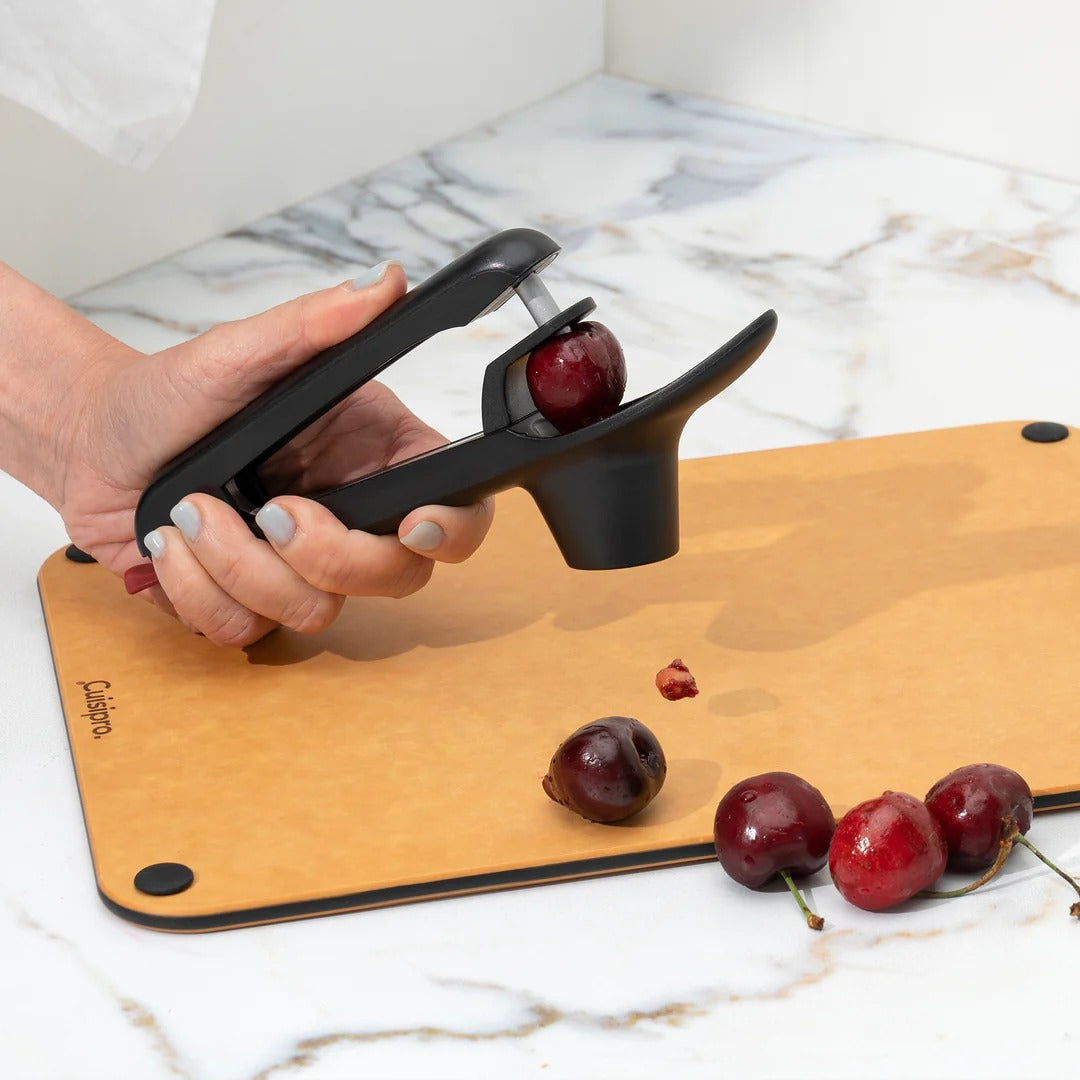 Hand cherry and olive pitter with handle, base, and red cup opening