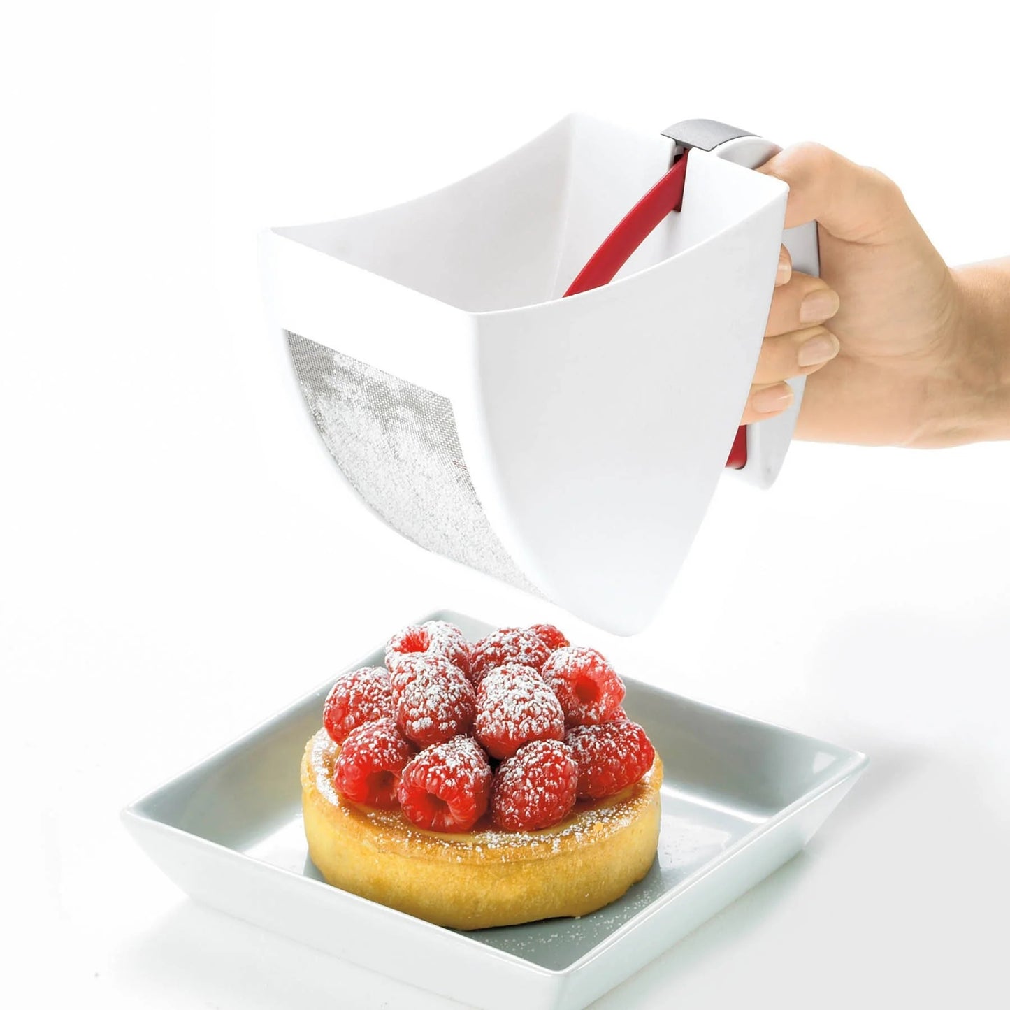 Flour sifter pouring flour over pastry, red handle and white scoop