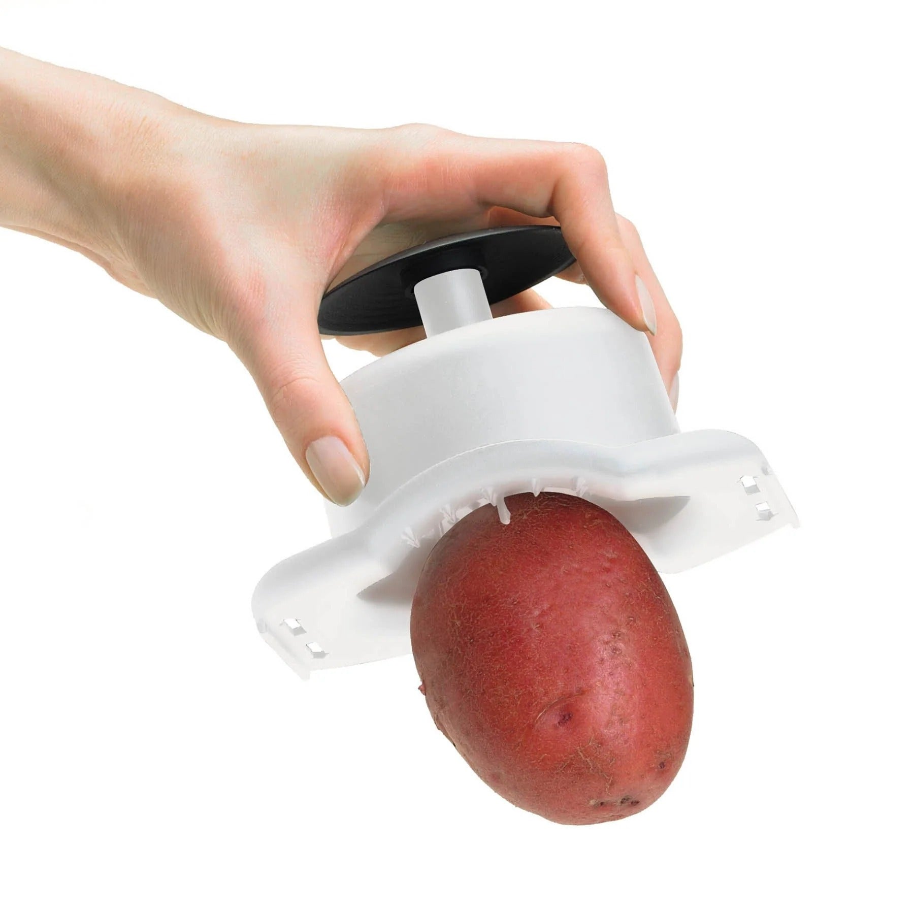 Handheld mandoline slicer with white carriage and black blade housing, held by hand.